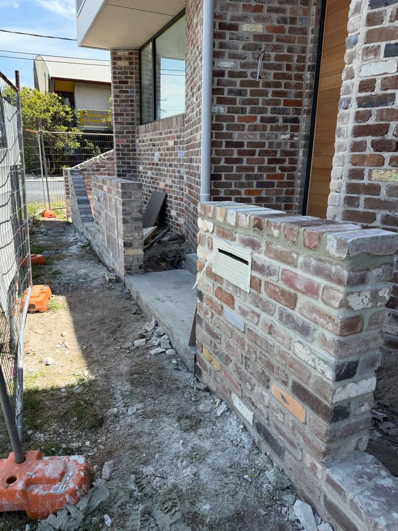 Brick fence return with a letterbox opening