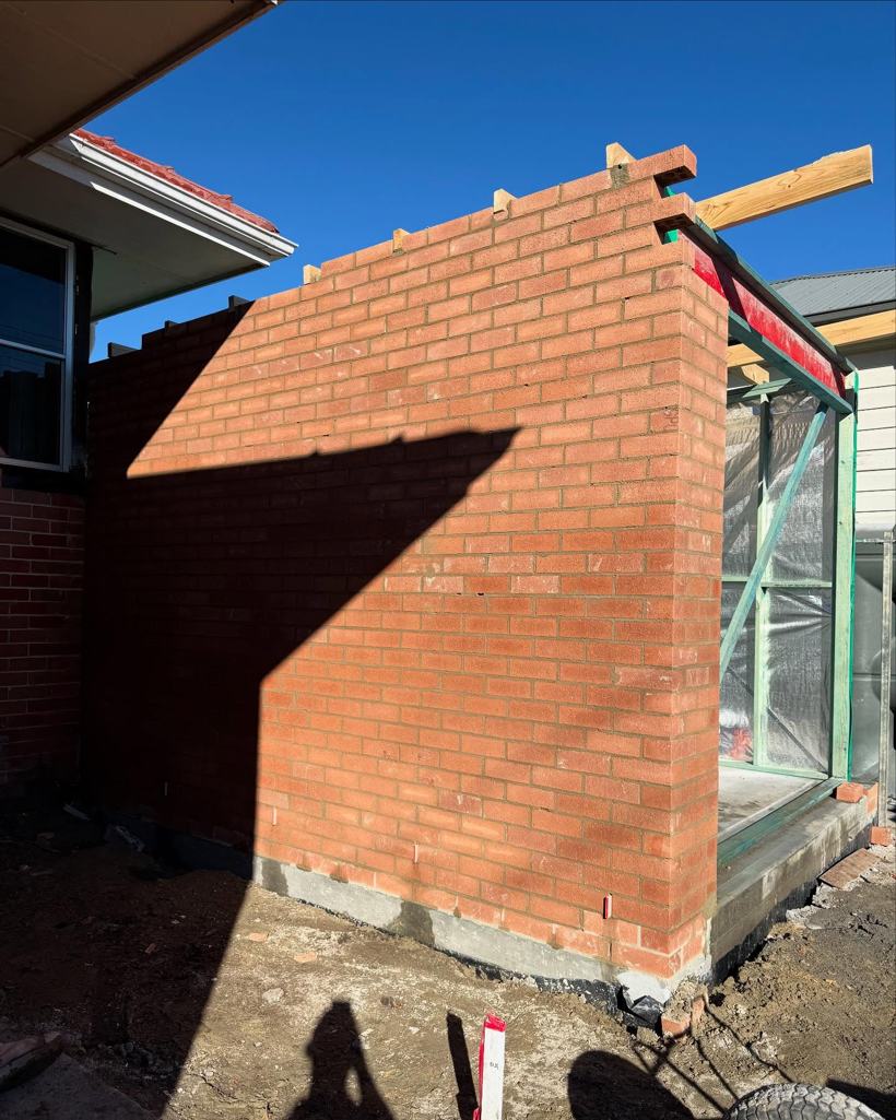Completed red brick gable wall on a garage addition