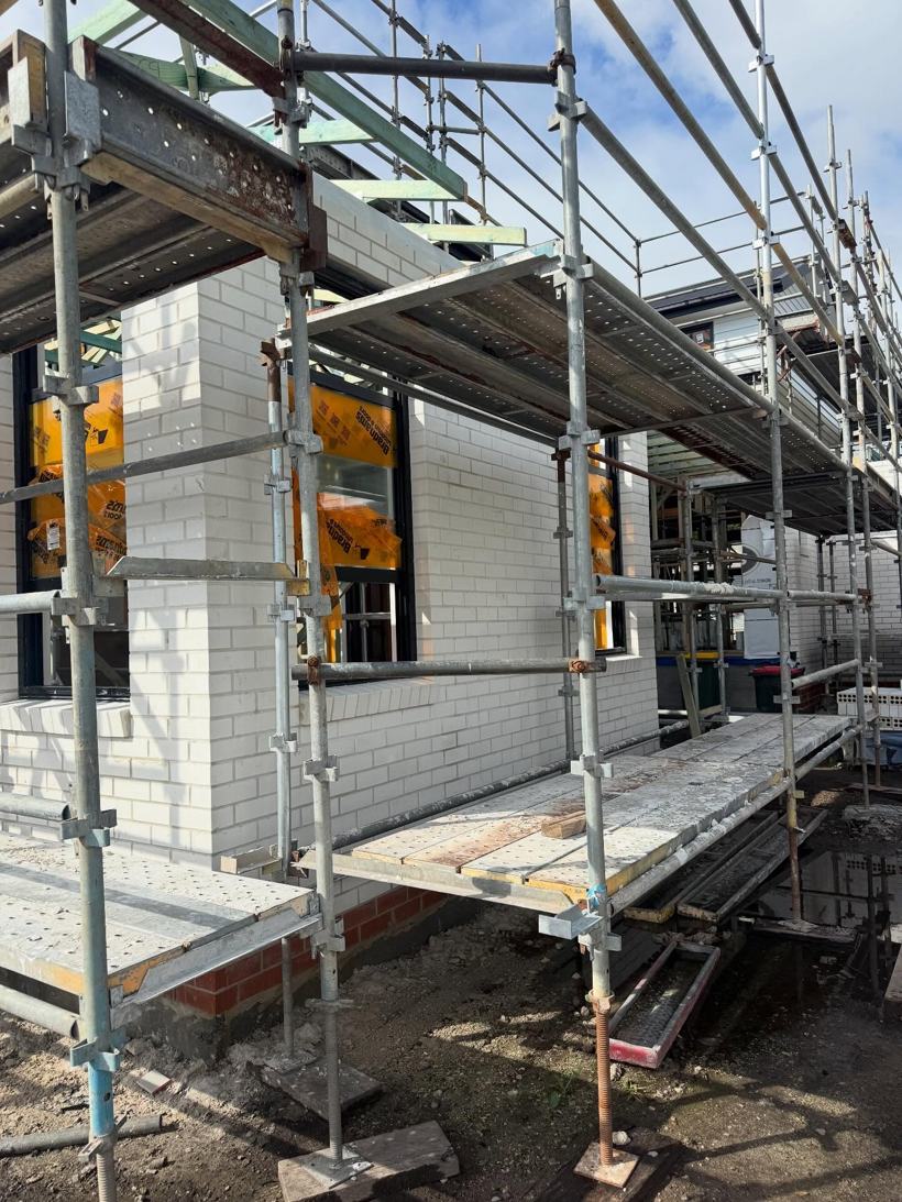 Glazed white face brick going up under scaffolding