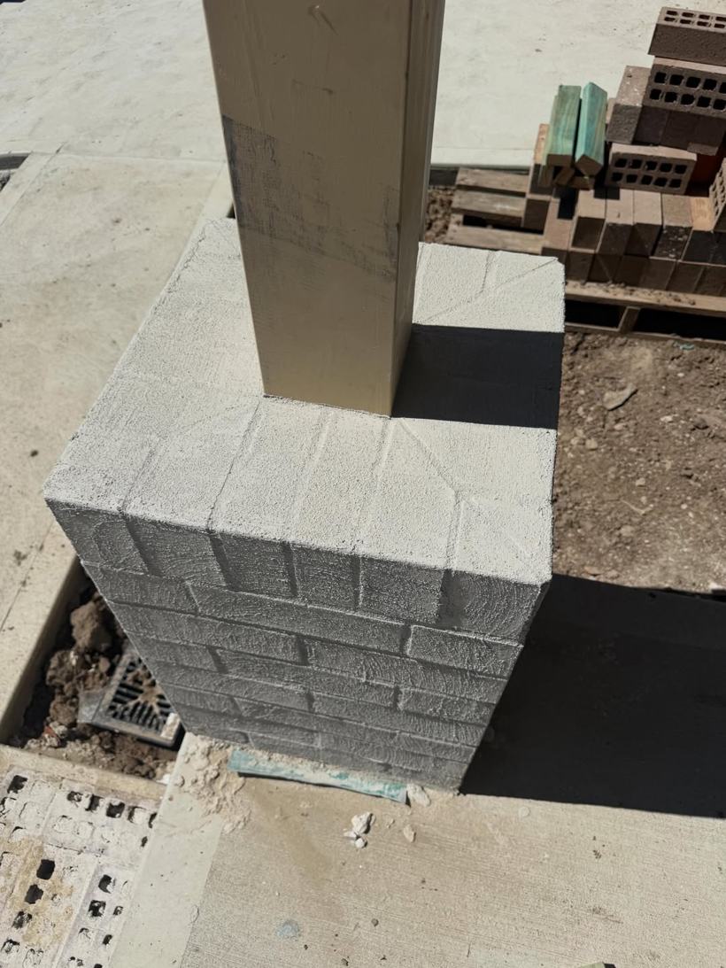 Concrete block pier built against a post